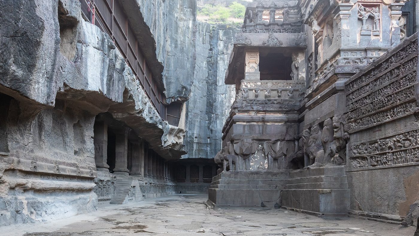 The temple in its court — galleries and epic reliefs cut into the living scarp.