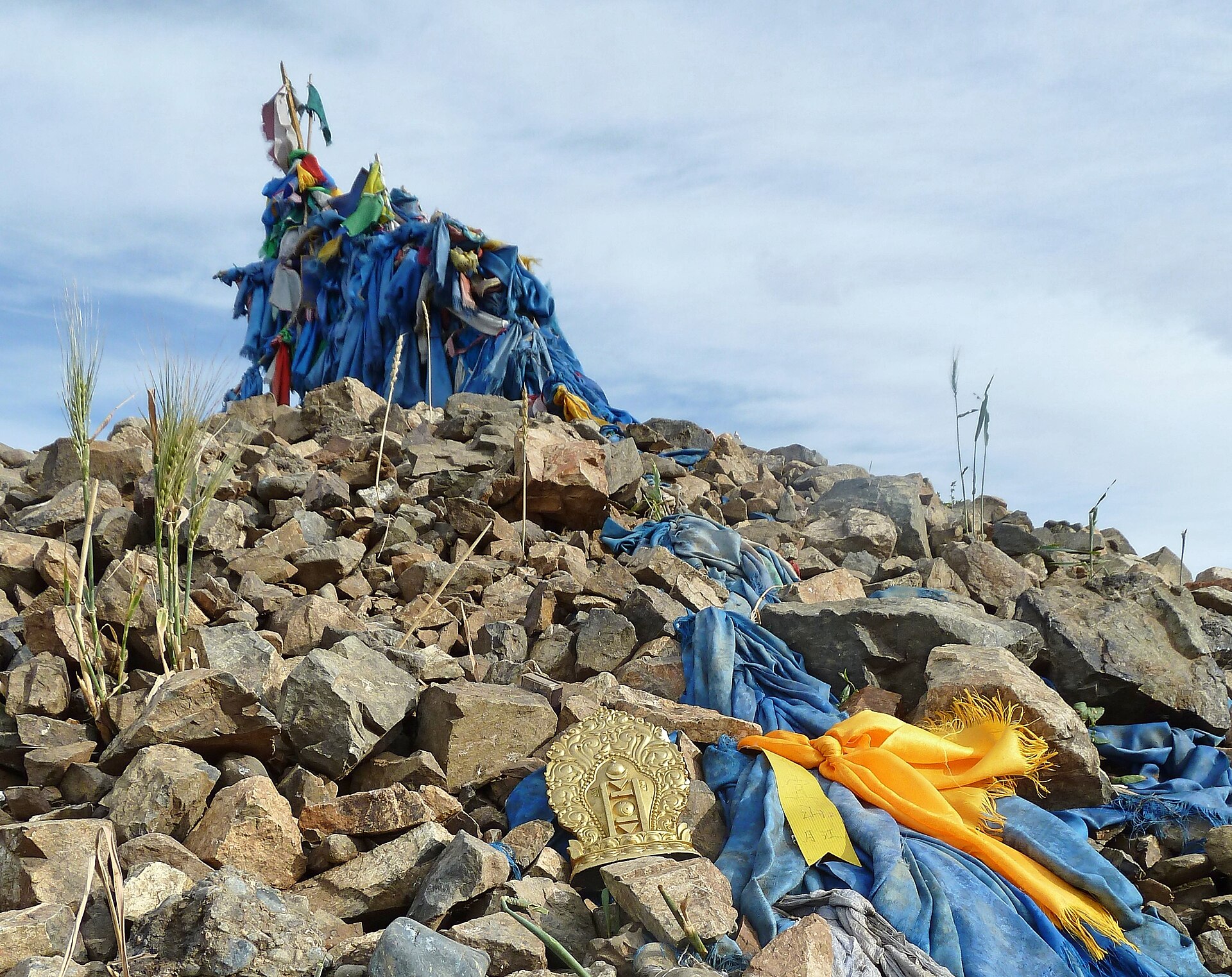 An ovoo cairn — circled three times clockwise; the book shows the threshold and looks away.